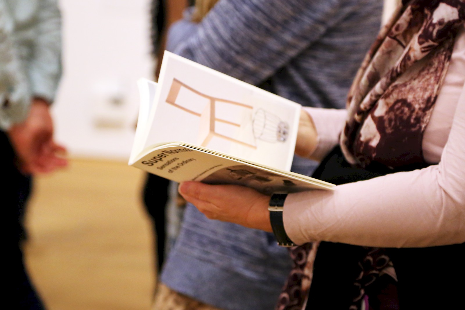 Fiona Knecht, Museum für Gestaltung am 20. April 2016, Besucherin blättert im Katalog zur Ausstellung "SuperNormal", ©VID/ZHDK 2016